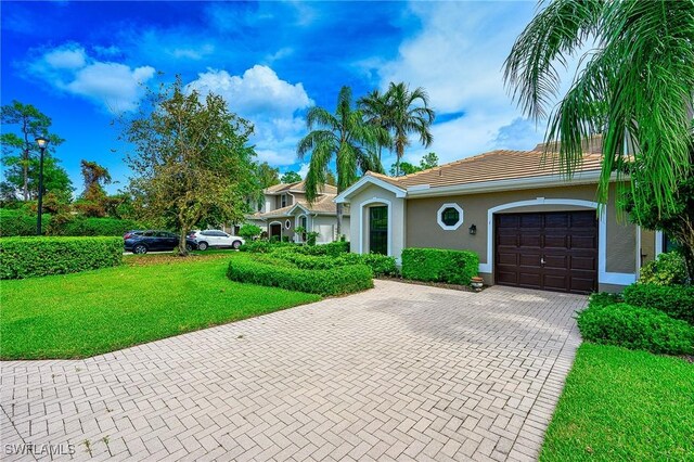 7670 Meadow Lakes Dr Unit 1501, Naples, FL 34104 - ranch-style home with a tiled roof, stucco siding, an attached garage, decorative driveway, and a front yard