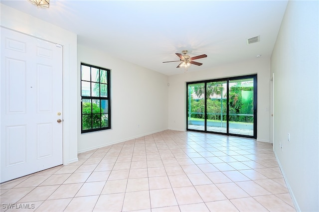 empty room featuring ceiling fan and light tile patterned floors