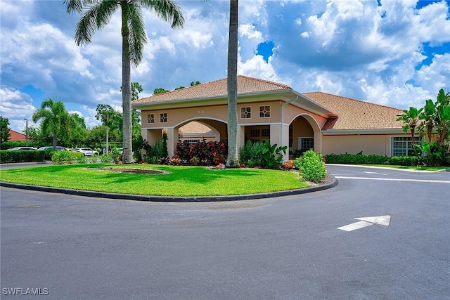 7670 Meadow Lakes Dr Unit 1501, Naples, FL 34104 - mediterranean / spanish-style house featuring stucco siding, a front lawn, and a tiled roof