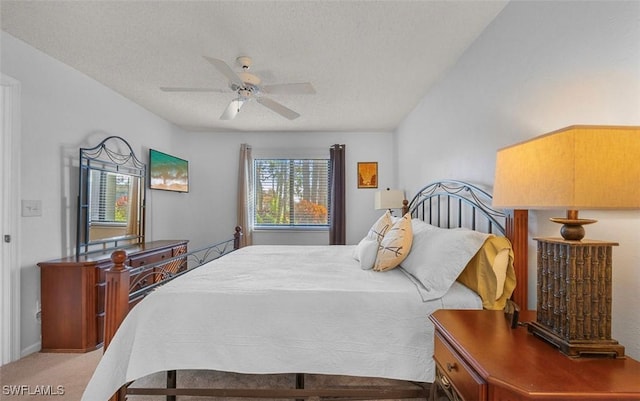 carpeted bedroom with ceiling fan and a textured ceiling