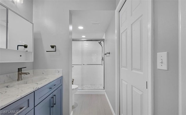 bathroom featuring tile patterned floors, vanity, toilet, and walk in shower