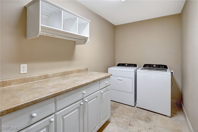 laundry room featuring washer and clothes dryer and cabinets