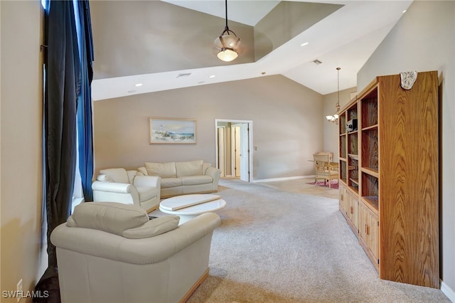 carpeted living room featuring an inviting chandelier and high vaulted ceiling