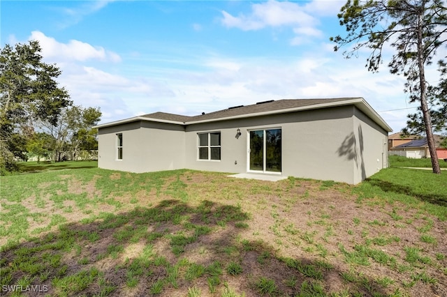 rear view of property with a lawn