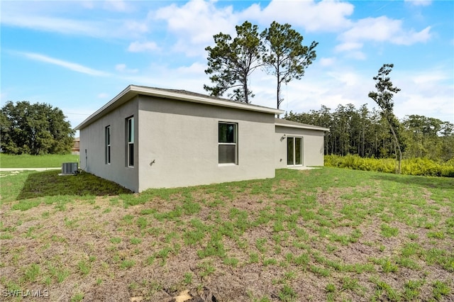 back of property featuring a yard and central air condition unit