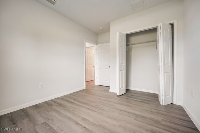 unfurnished bedroom featuring light wood-type flooring and a closet