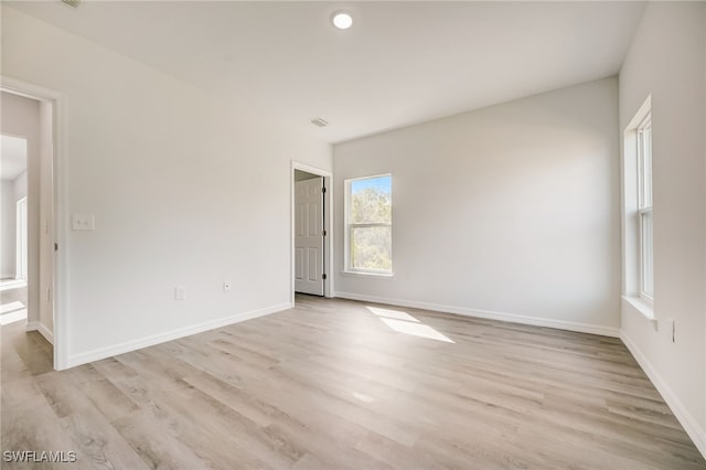 spare room featuring a wealth of natural light and light wood-type flooring