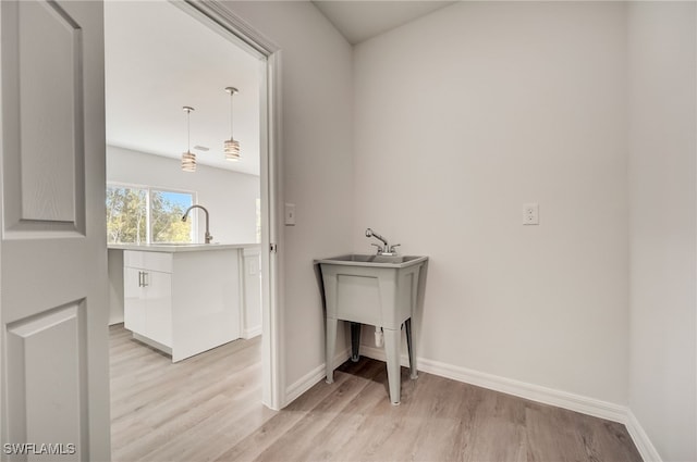 laundry room with sink and light wood-type flooring