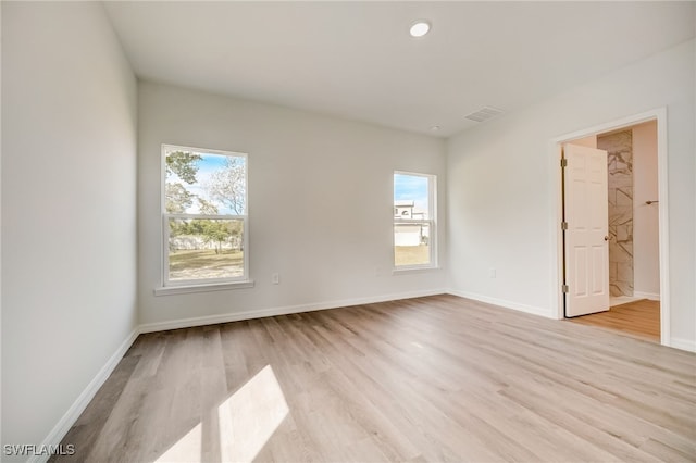 unfurnished room featuring plenty of natural light and light hardwood / wood-style floors