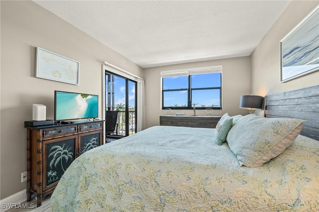 803 River Point Dr Unit 306B, Naples, FL 34102 - bedroom featuring baseboards, access to exterior, and wood finished floors