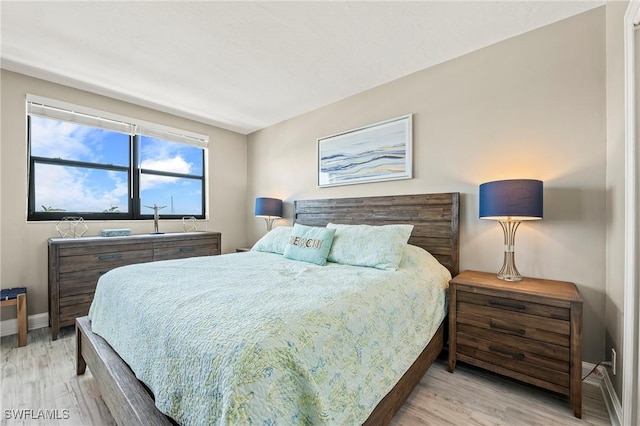 803 River Point Dr Unit 306B, Naples, FL 34102 - bedroom featuring baseboards and wood finished floors