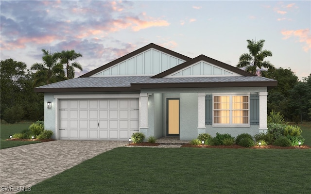 view of front of home with a garage and a lawn