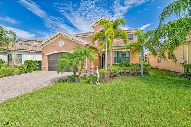 mediterranean / spanish home featuring a front lawn and a garage