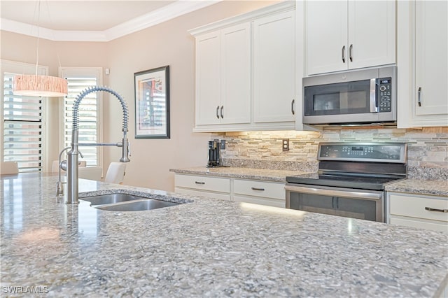 kitchen featuring light stone counters, stainless steel appliances, sink, and white cabinets