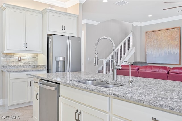 kitchen with sink, crown molding, white cabinetry, appliances with stainless steel finishes, and light stone counters