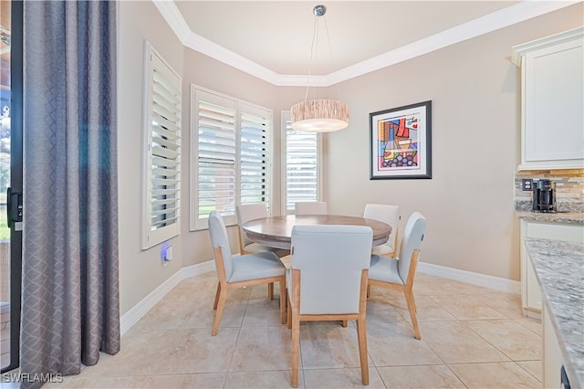 tiled dining room featuring crown molding