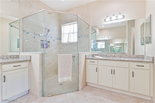 bathroom featuring a shower with door, vanity, and tile patterned floors