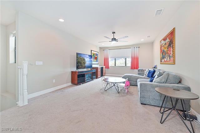 carpeted living room with ceiling fan