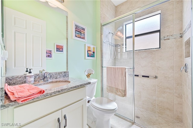 bathroom with vanity, tile patterned flooring, toilet, and walk in shower