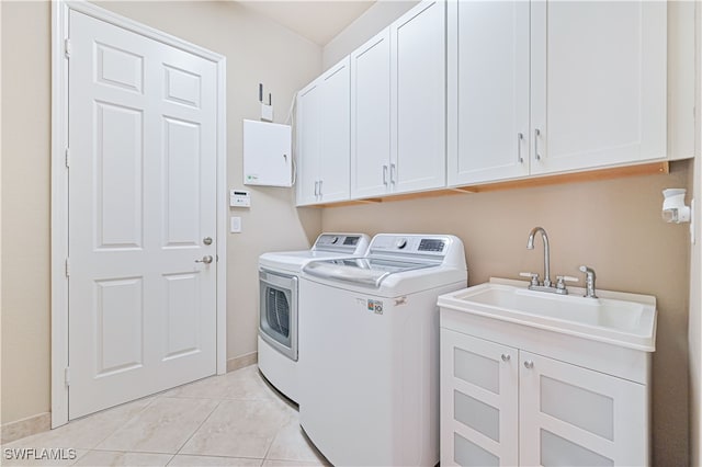 clothes washing area featuring cabinets, light tile patterned flooring, sink, and washing machine and dryer