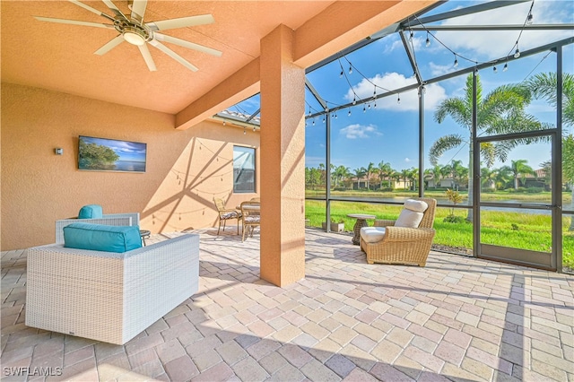 view of patio / terrace featuring ceiling fan and glass enclosure