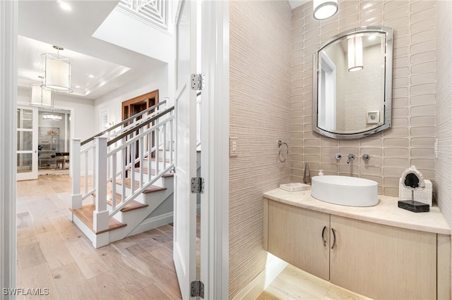 bathroom featuring tile walls, vanity, hardwood / wood-style flooring, and a tray ceiling