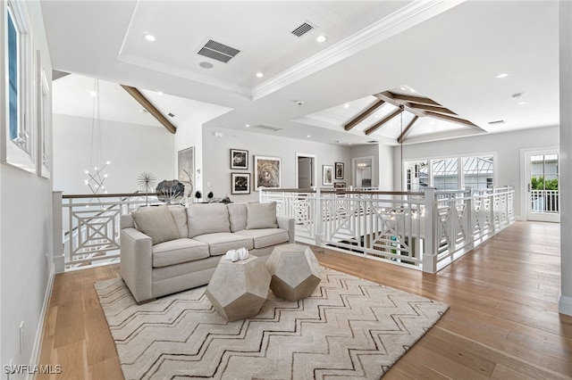 living room with a notable chandelier, ornamental molding, light hardwood / wood-style flooring, and vaulted ceiling with beams