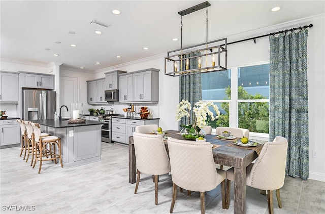 dining space with crown molding and sink