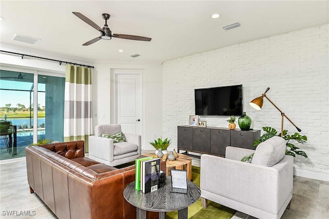 living room with ceiling fan and brick wall