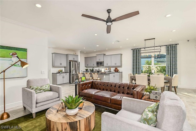 living room with ceiling fan, light hardwood / wood-style flooring, and crown molding