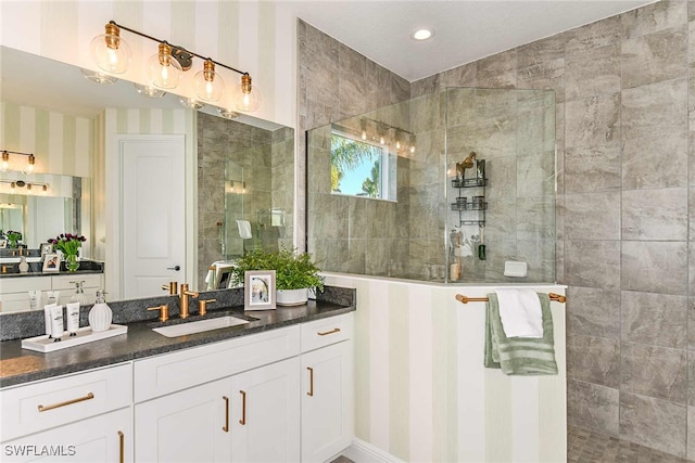 bathroom featuring a tile shower and vanity