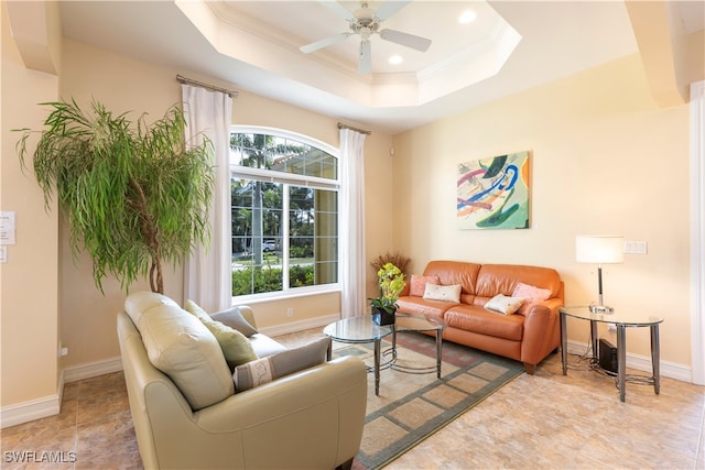 living room with ceiling fan, a tray ceiling, and a healthy amount of sunlight