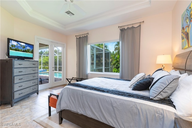 bedroom with ceiling fan, access to exterior, a tray ceiling, and french doors