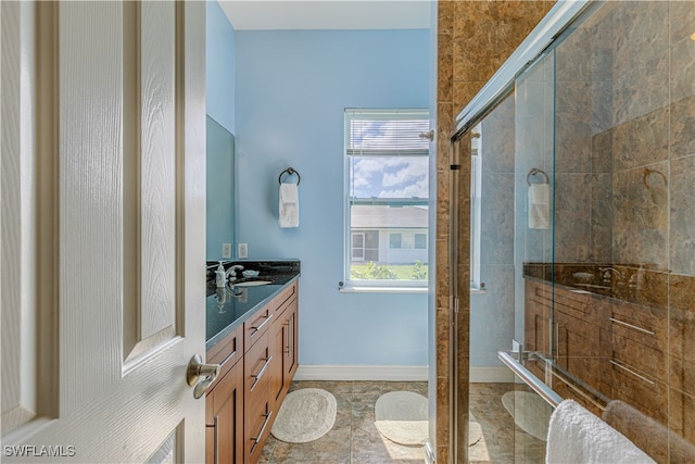 bathroom featuring plenty of natural light, a shower with door, and vanity