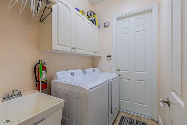 washroom with cabinets, sink, and washer and clothes dryer