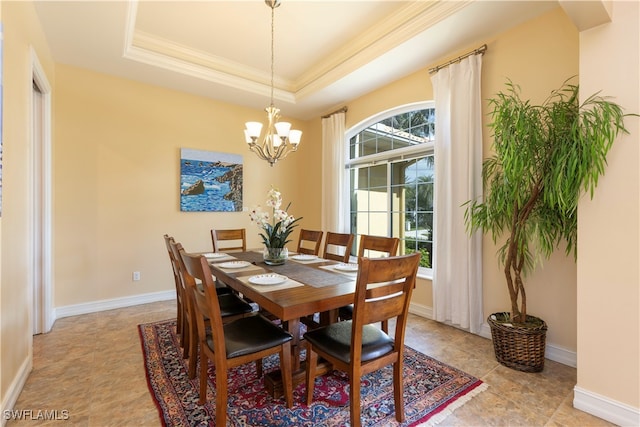 dining space with ornamental molding, a tray ceiling, and an inviting chandelier