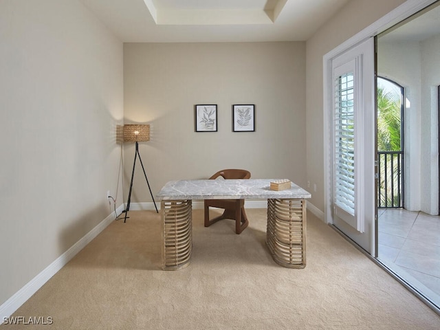 carpeted office featuring a tray ceiling