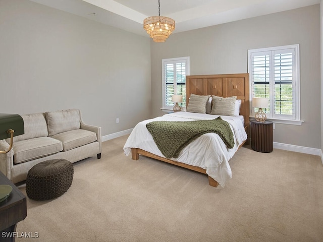 bedroom featuring an inviting chandelier and light carpet