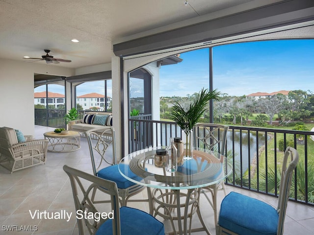 sunroom / solarium with a water view and ceiling fan