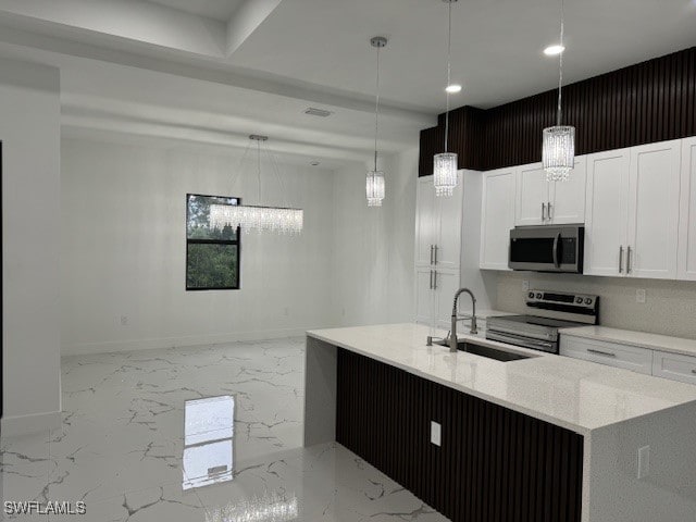 kitchen featuring pendant lighting, white cabinetry, sink, and stainless steel appliances