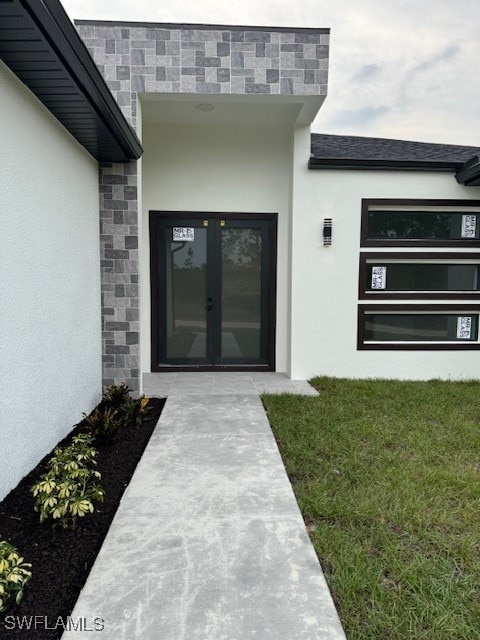 doorway to property featuring french doors and a yard