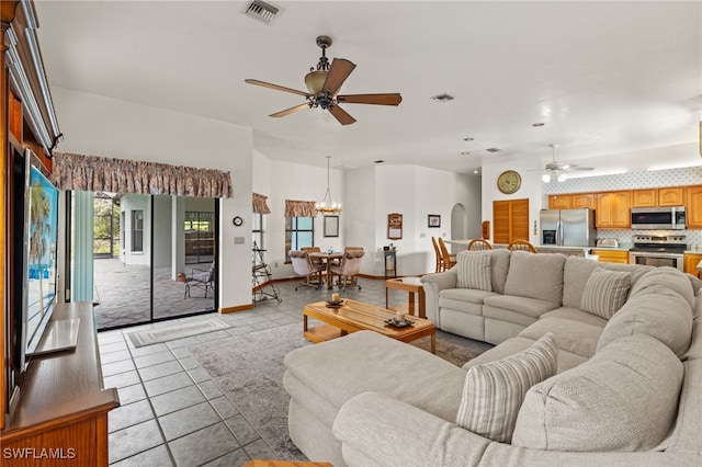 living room with light tile patterned floors and ceiling fan with notable chandelier