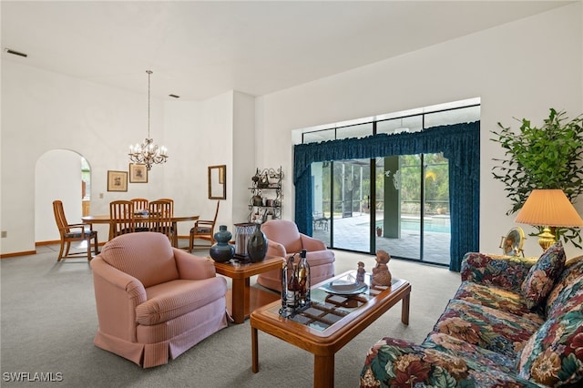 carpeted living room featuring a chandelier