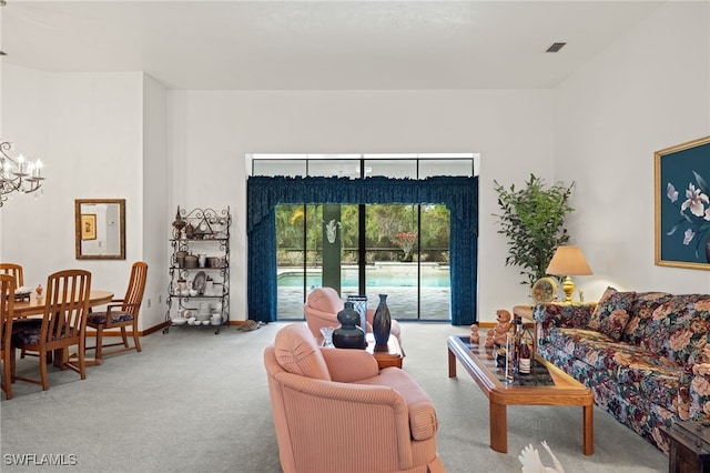 living room featuring a chandelier and carpet flooring