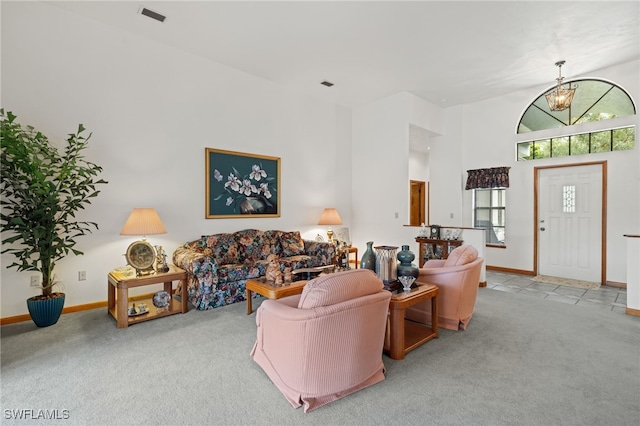 living room with a notable chandelier, a high ceiling, and light colored carpet