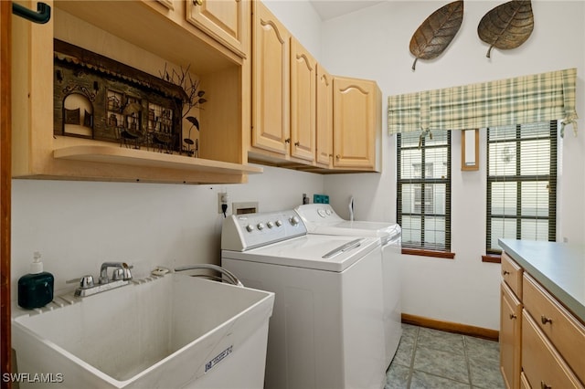 clothes washing area featuring cabinets, light tile patterned flooring, sink, and separate washer and dryer