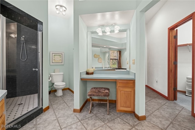 bathroom with vanity, a tile shower, tile patterned floors, and toilet