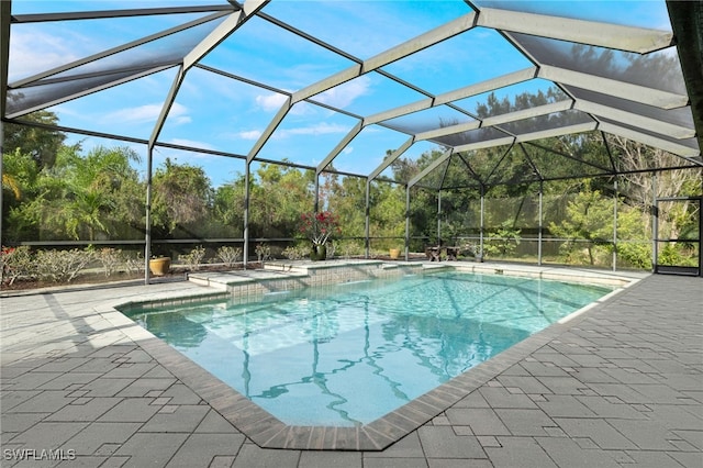 view of pool with a patio area and glass enclosure