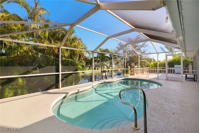 view of pool featuring a water view, glass enclosure, and a patio area