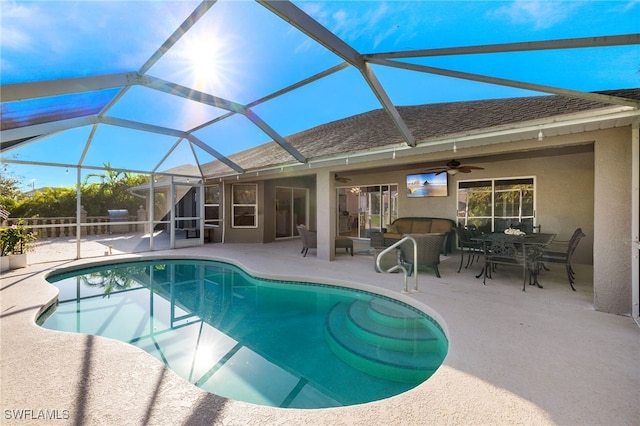 view of pool featuring glass enclosure, ceiling fan, and a patio